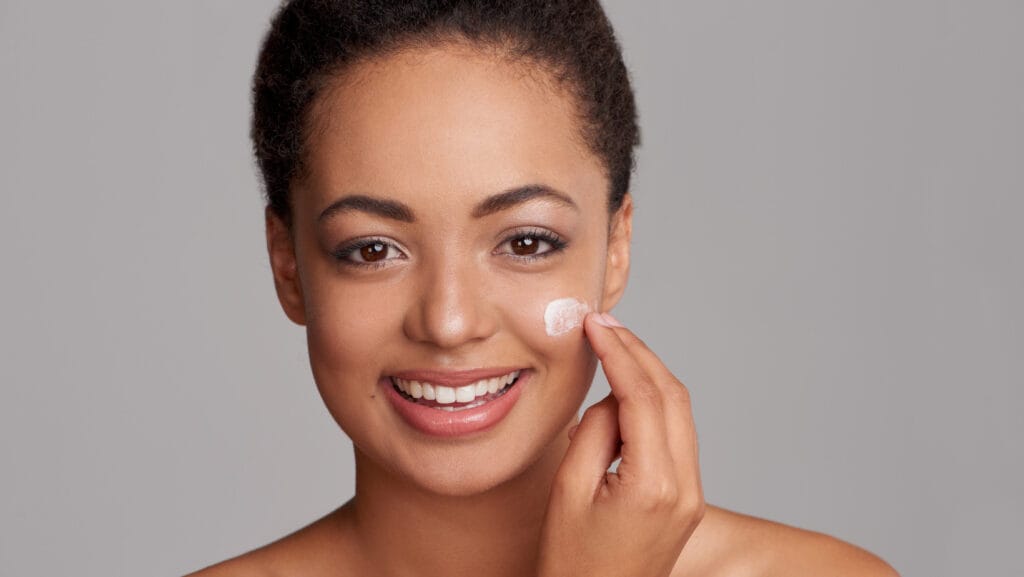 אישה שמה קרם לחות על עור יבש