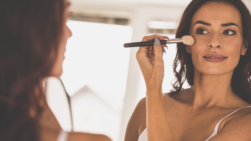 אישה שמה סומק עם מברשת