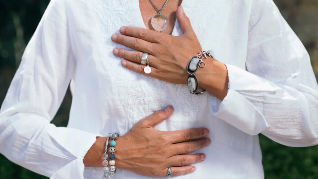 אישה שמה את הידיים על החזה כחלק ממדיטציה