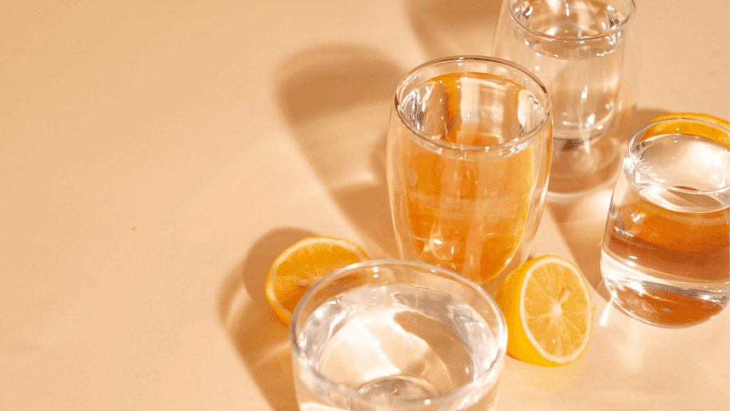 ויטמין C עם כוסות מים ופרוסות תפוז