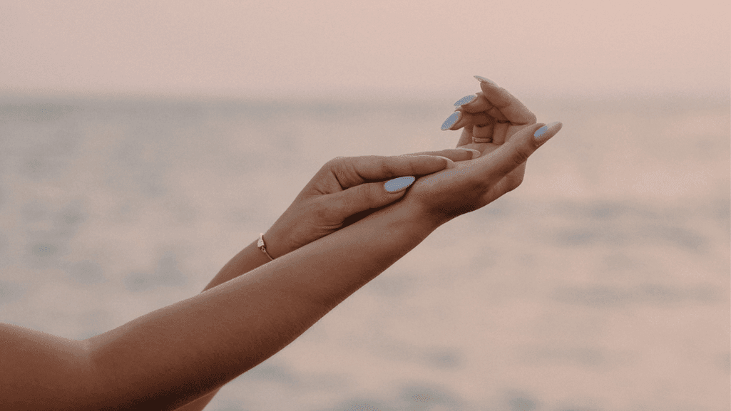 ידיים של אישה ברקע שקיעה