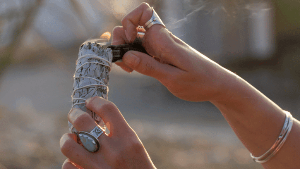 אישה מדליקה מרווה יבשה חלק מיוגה